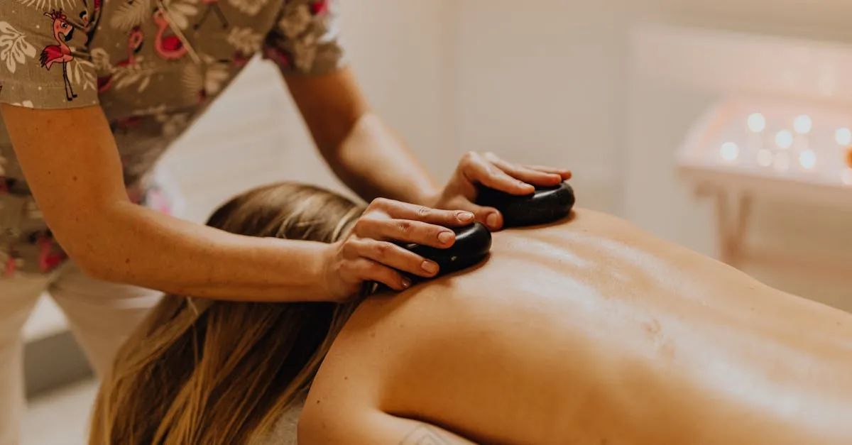 Warm stones placed along the back during a relaxing massage in a candle-lit room
